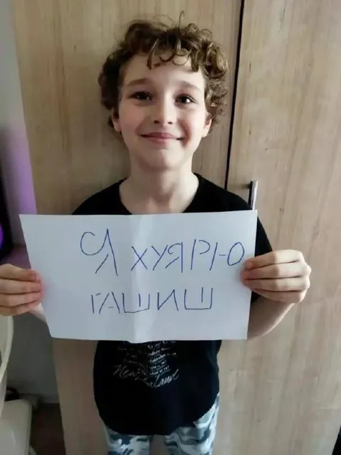 Ребёнок с неприличной табличкой