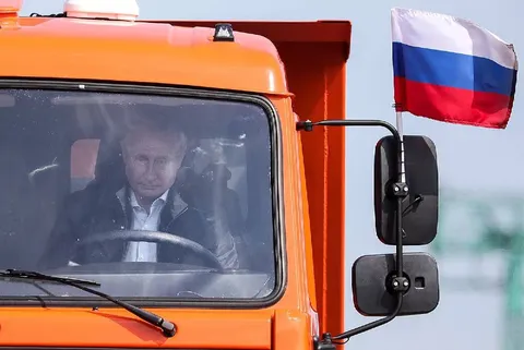 Путин за рулём оранжевого грузовика