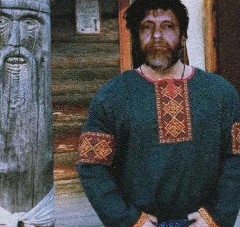 Бородатый мужик в избе