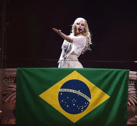 Cantora diante da bandeira do Brasil