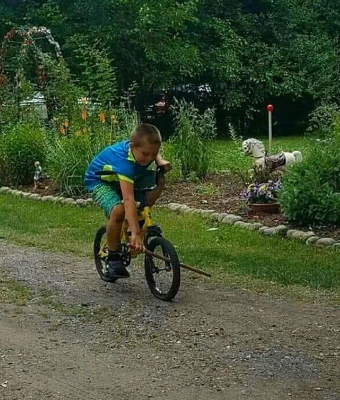 Мальчик чинит велосипед на ходу