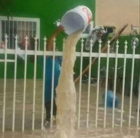 Человек льёт воду из ведра