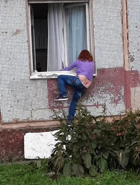 Женщина лезет в окно