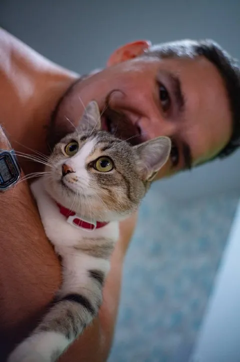 Мужчина обнимает кота