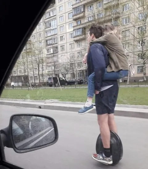 Парень везёт девушку на моноколесе