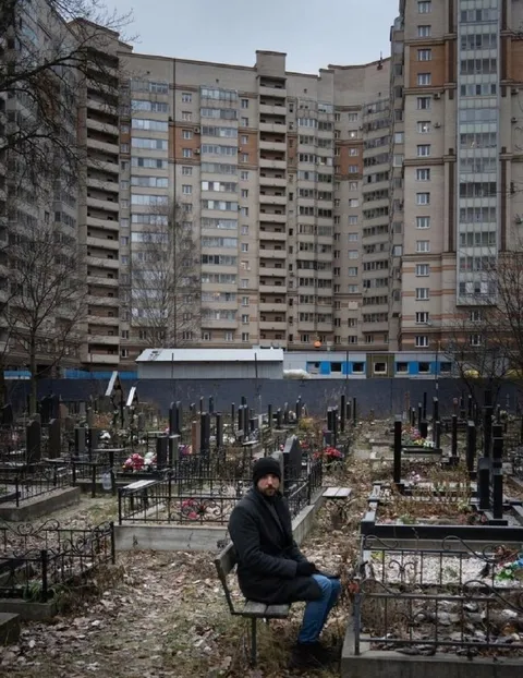 Мужчина сидит на кладбище