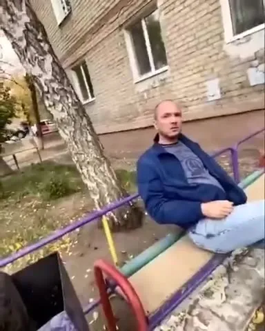 Мужчина на детских качелях