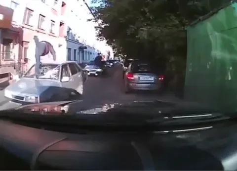 Человек на капоте автомобиля