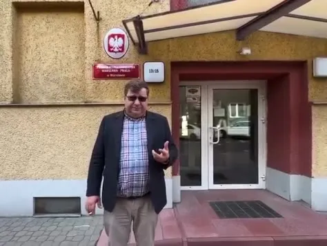 Мужчина объясняет у польского здания