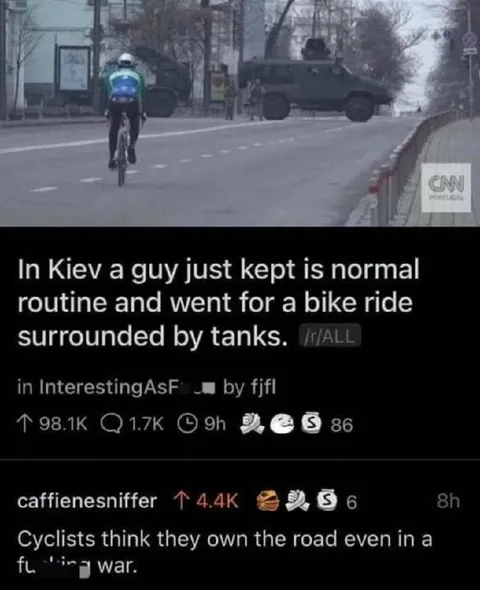 Cyclist Surrounded by Tanks