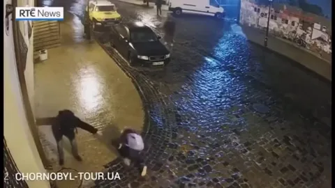 Женщина скользит на мокрой улице