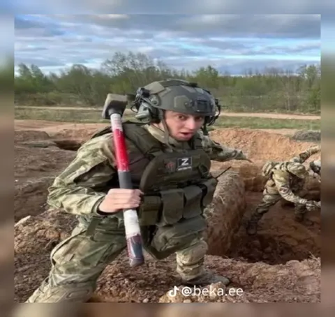 Солдат с лопатой в окопе