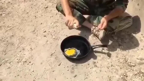 Солдат жарит яйцо на земле