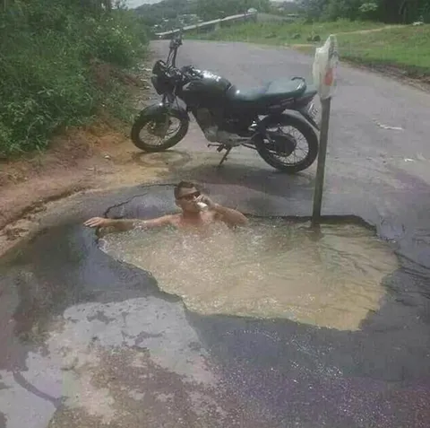 Мужчина принимает душ в луже