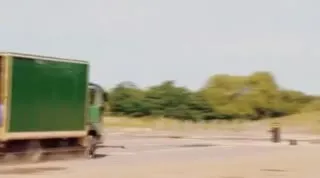Зелёный грузовик проносится мимо
