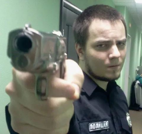 Полицейский целится в камеру