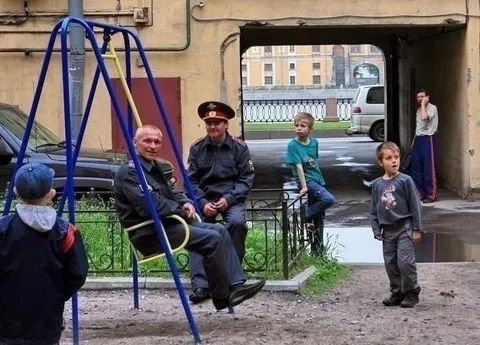 Путин на детских качелях