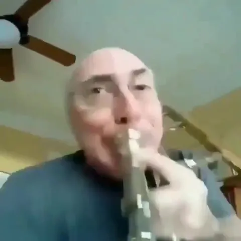 Лысый мужчина играет на тромбоне