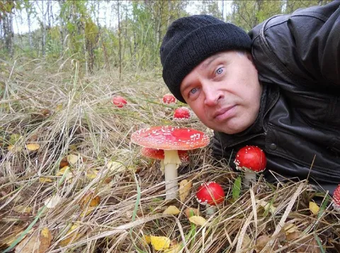 Мужчина среди мухоморов