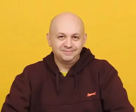 Лысый мужчина в худи улыбается