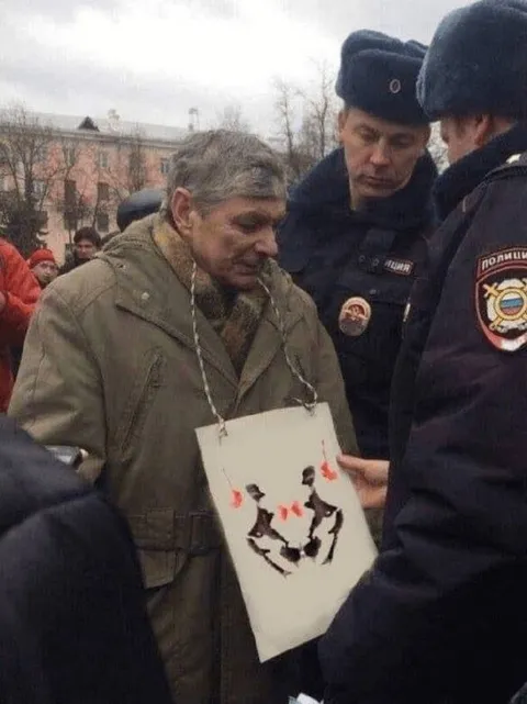 Мужчина с плакатом и полицией