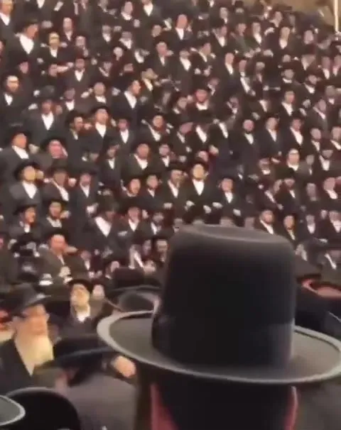 Танцующая толпа в чёрных шляпах