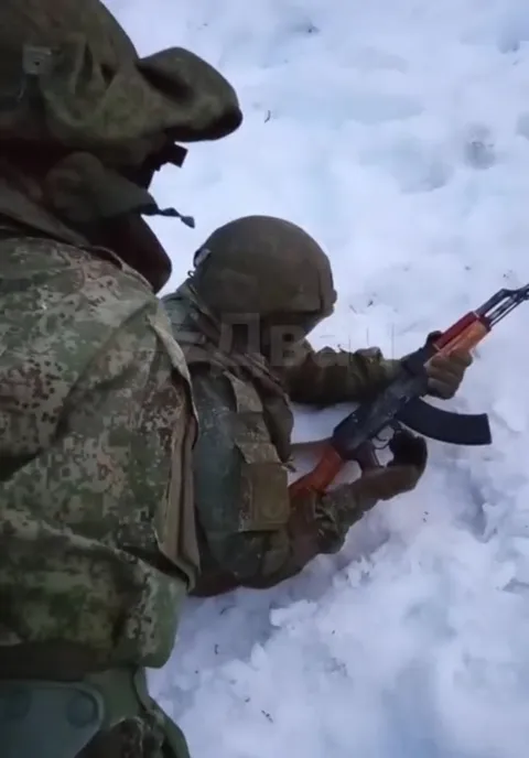 Солдаты делят автомат в снегу