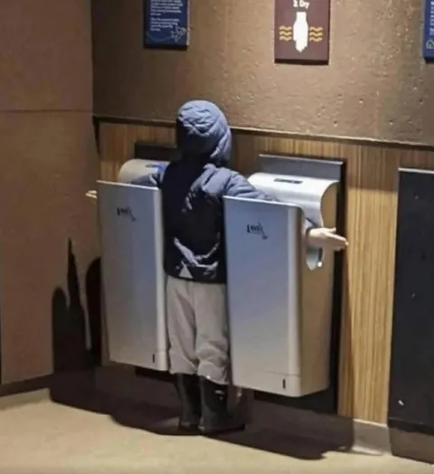 Person Between Two Hand Dryers