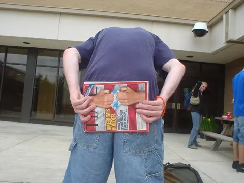 Headless Man Hides Behind Magazine