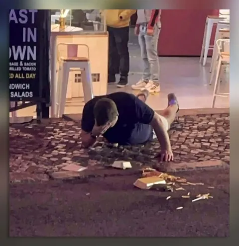 Man Crawling Out of a Restaurant