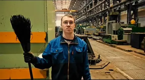 Рабочий играет каской в футбол