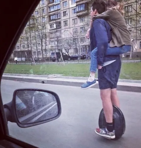 Парень везёт девушку на моноколесе