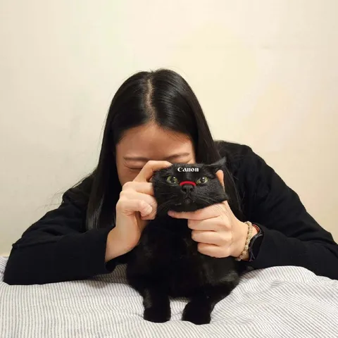 Девушка фотографирует чёрного кота