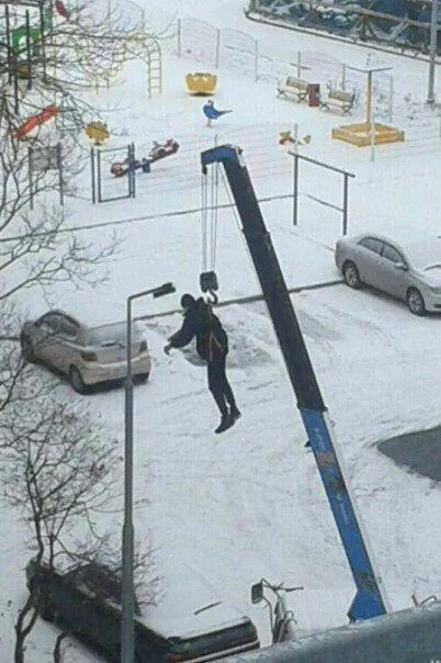 Человек на крюке крана