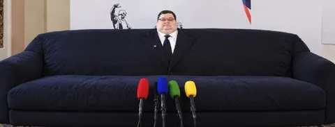 Мужчина за огромным диваном
