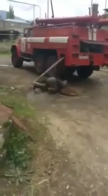 Человек под пожарной машиной