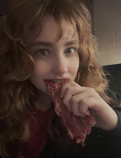 Девушка ест сырое мясо