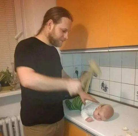 Отец шлёпает младенца тапком
