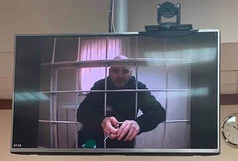 Мужчина за решёткой на экране