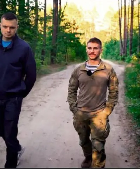 Мужчины идут по лесной дороге