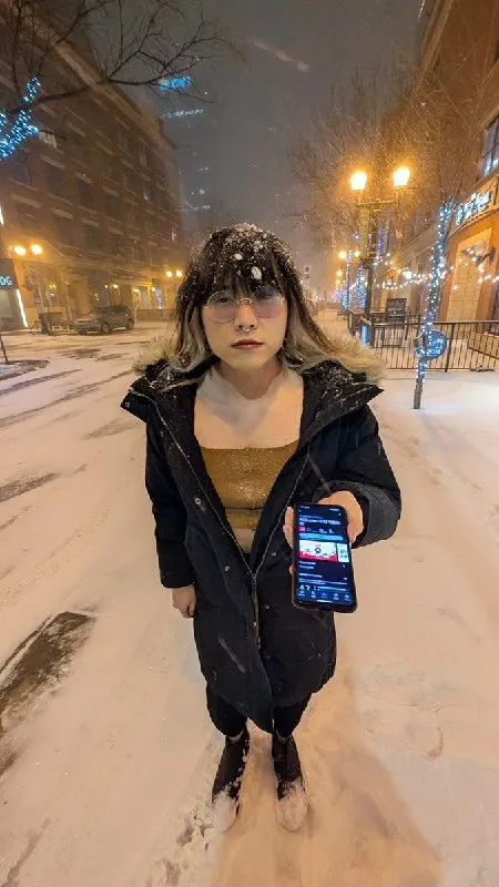 Девушка показывает телефон в снегу