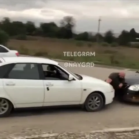 Мужчина между дымящимися машинами
