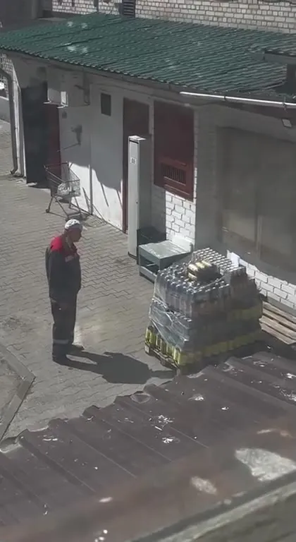 Мужчина смотрит на паллет напитков