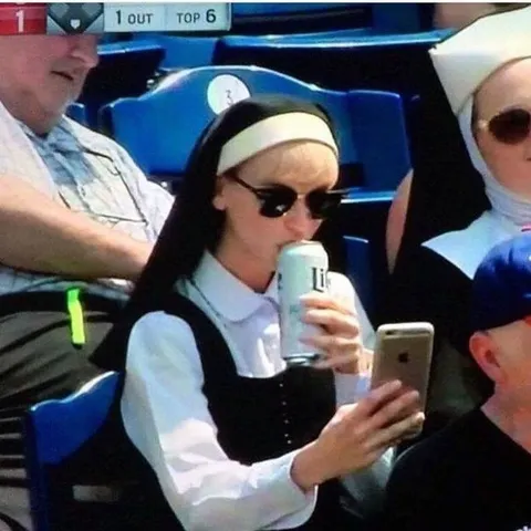 Nun Drinking Beer at Baseball Game