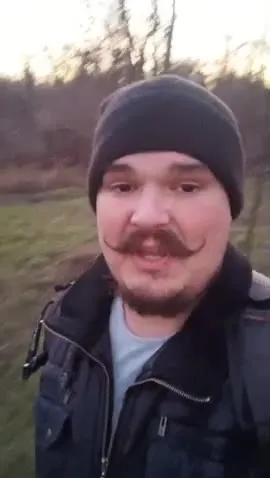 Мужчина выпивает в лесу
