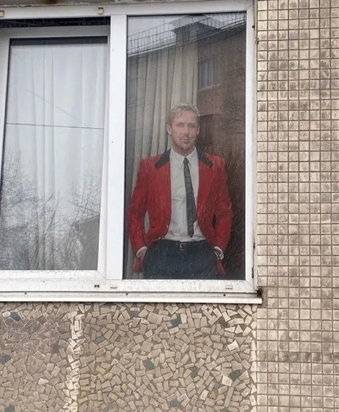 Мужчина за окном в красном пиджаке