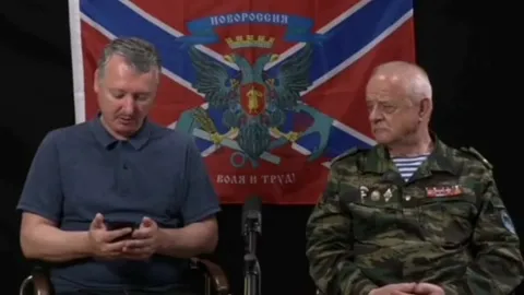 Боец листает фотографии с фронта