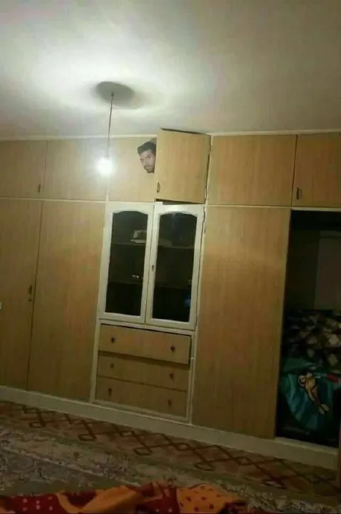 Мужчина выглядывает из шкафа