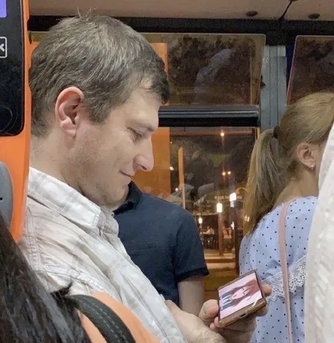 Мужчина показывает телефон в автобусе