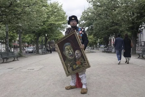 Уличный художник с необычной картиной